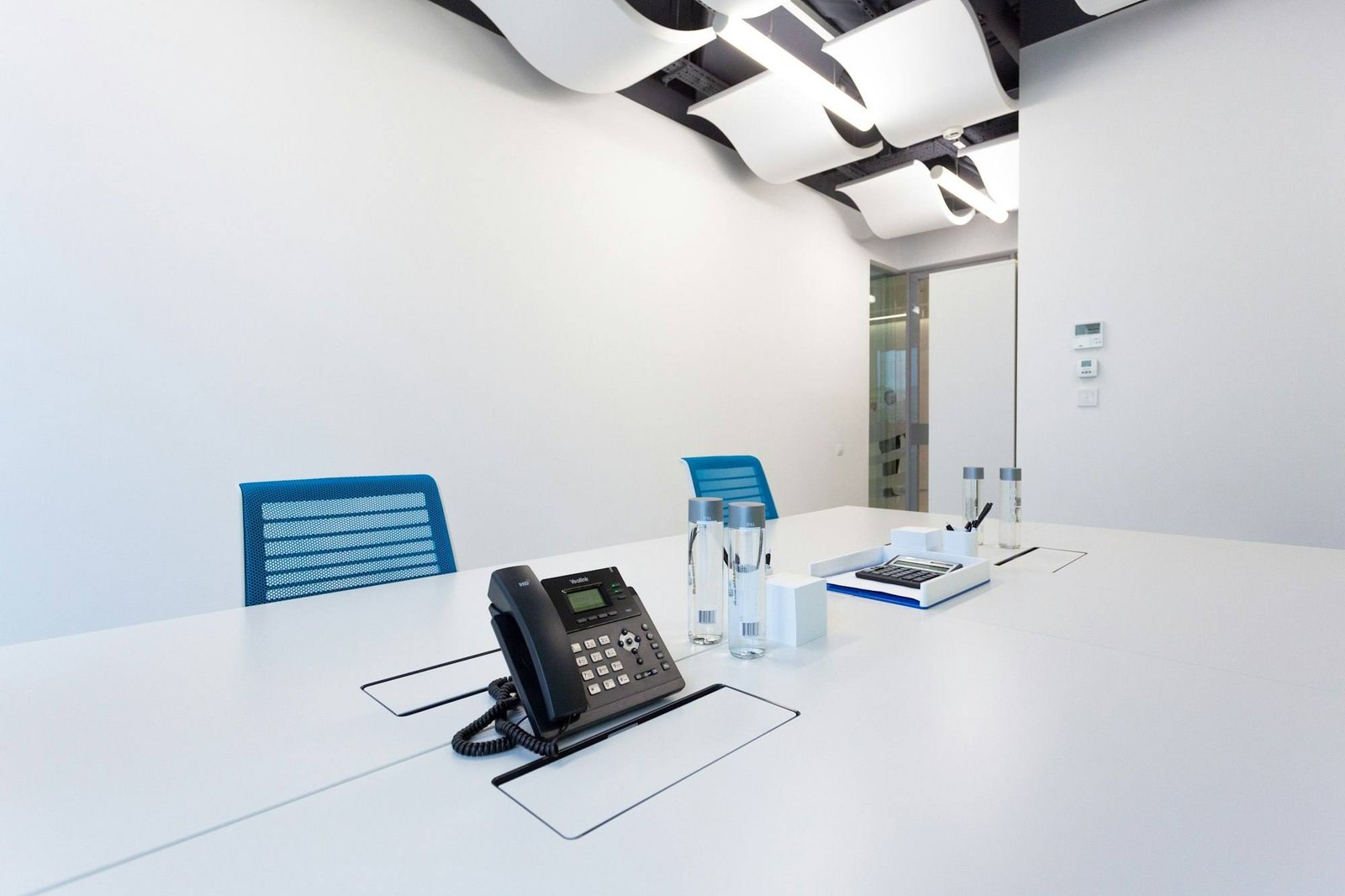IP desk phone on a white table in a bright meeting room