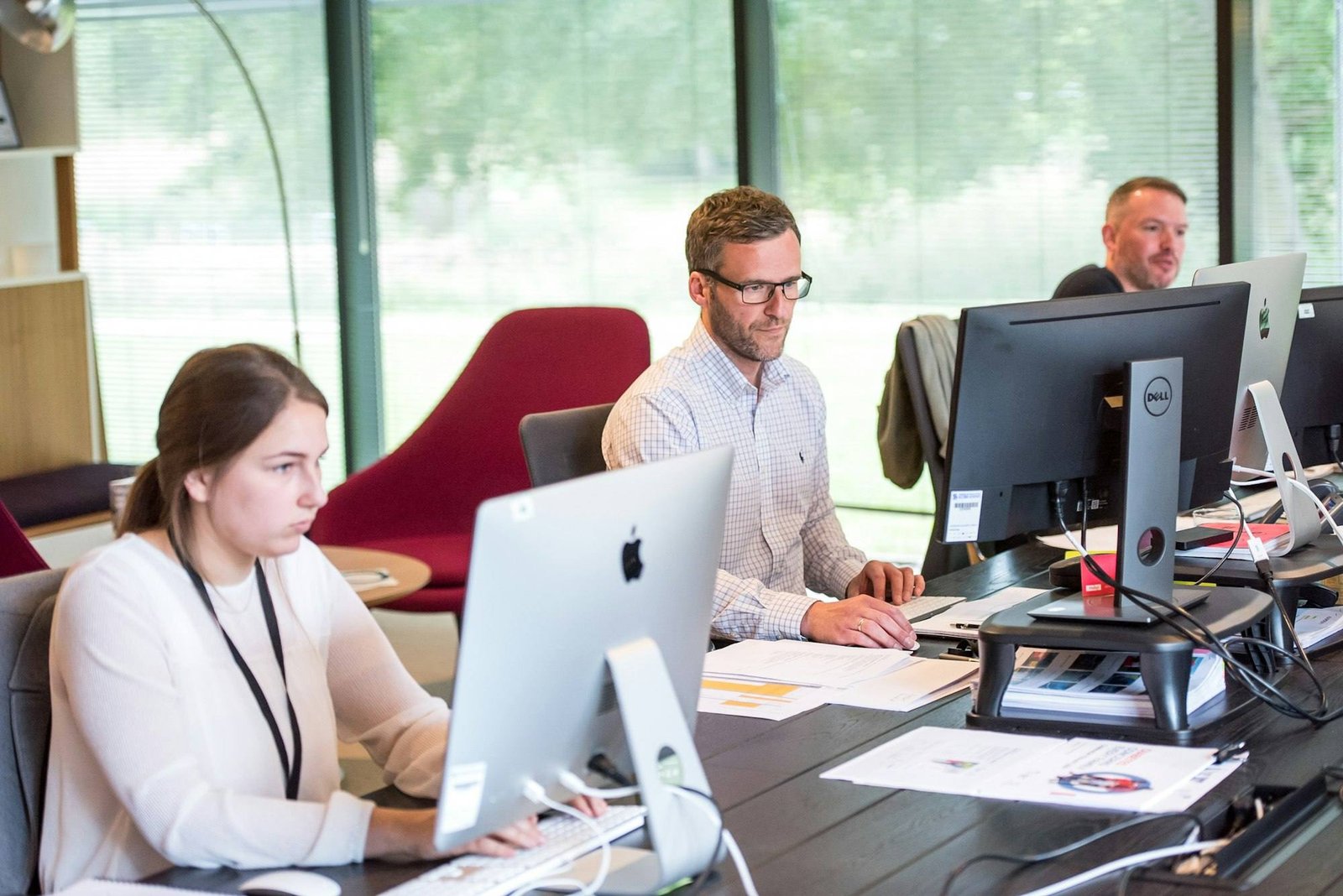 Colleagues working at computer workstations in a bright open-plan office