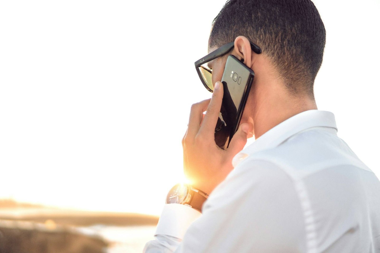 Professional in a white shirt taking a call on a smartphone